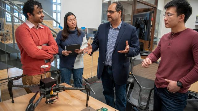 Group of people looking at a robot on a table